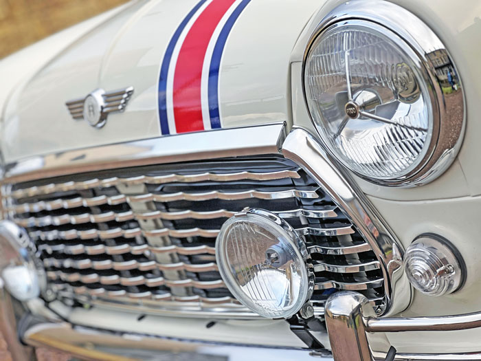 Classic Mini EV fitted with a wavy front grille, Mk1 style bumper overriders and P700 headlights.